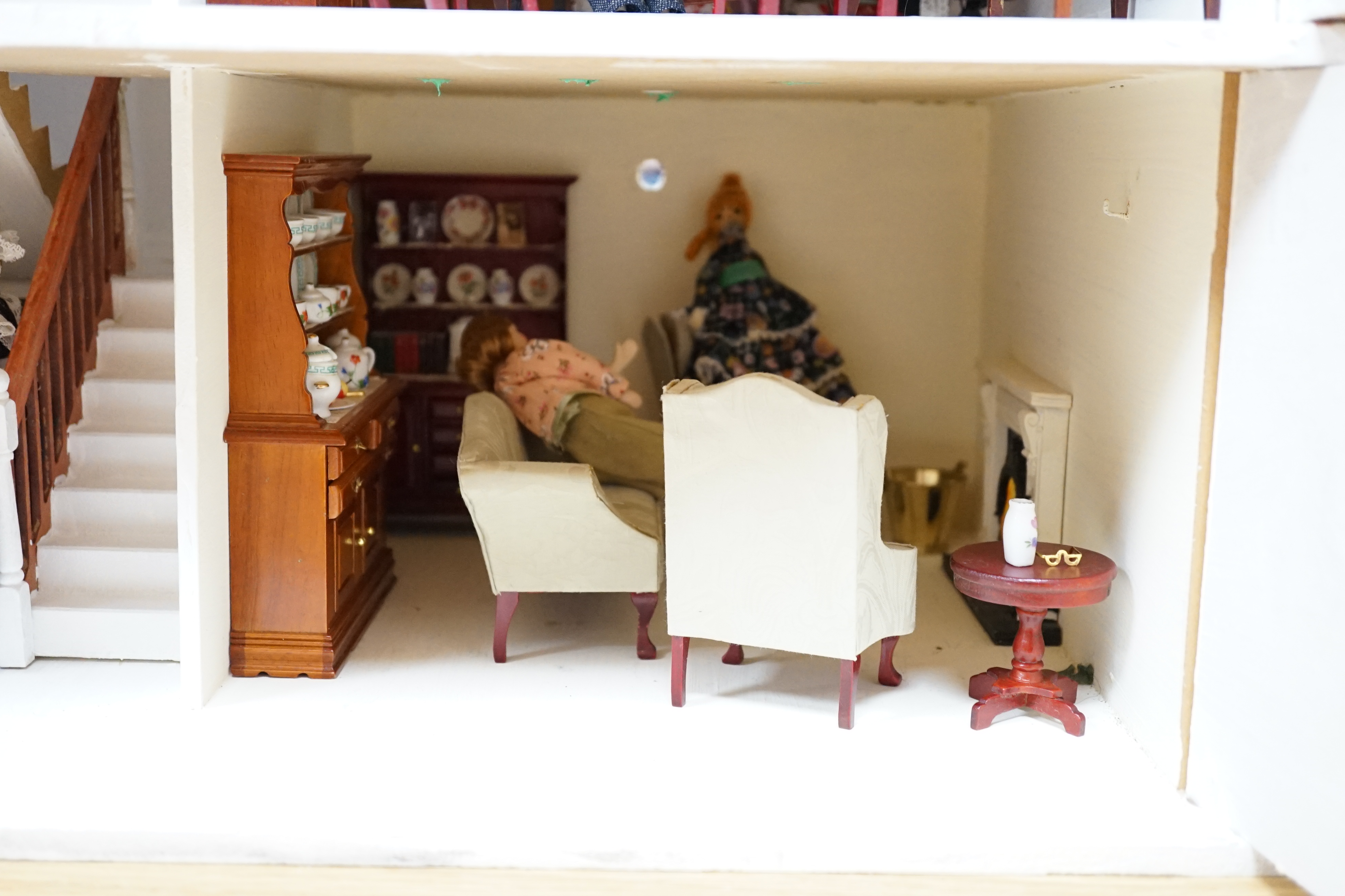 A painted doll's house with dolls and furniture, dolls house 78.5cm wide, 67cm high